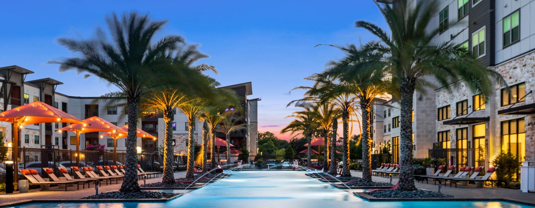 a pool with palm trees and buildings