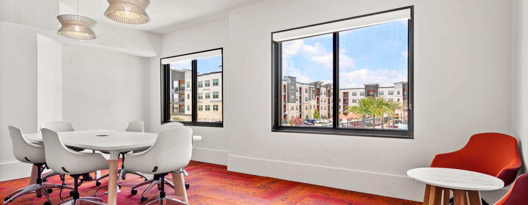 a room with a table chairs and a large window